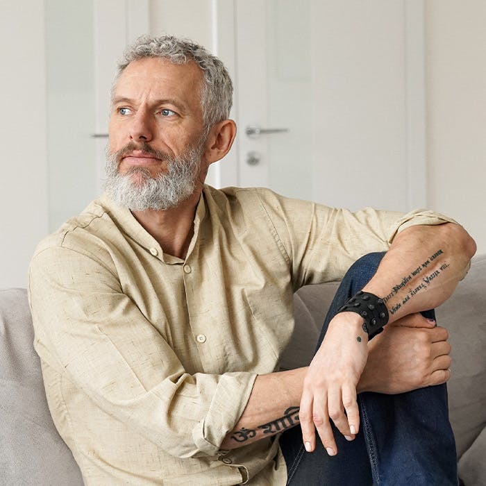 man on couch looking out the window