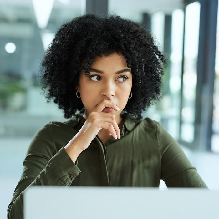 a woman thinking while on the laptop