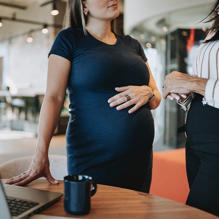 pregnant woman near table with laptop