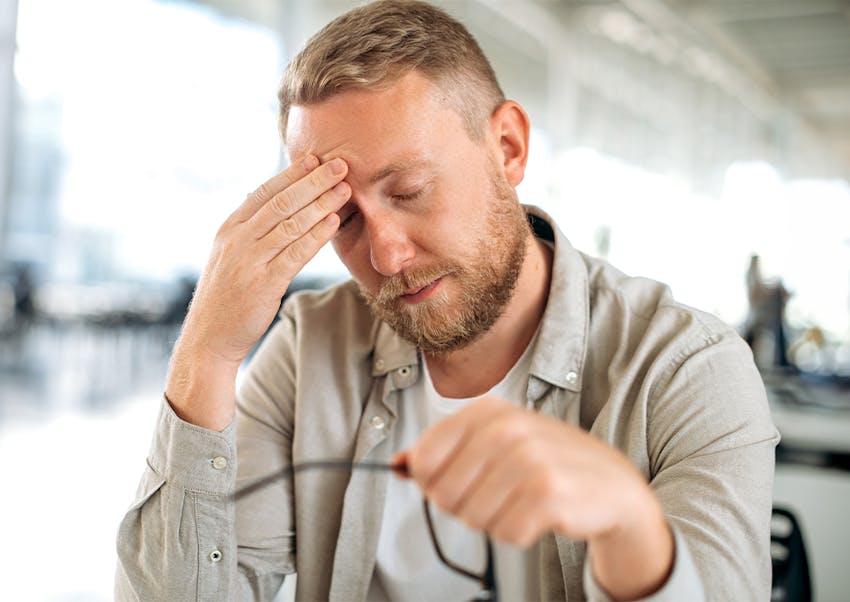 man touching forehead