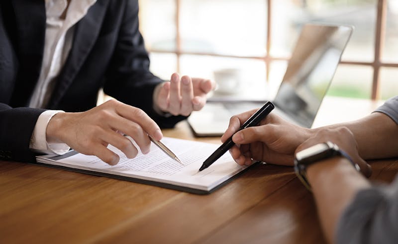 Attorney showing a client where to sign