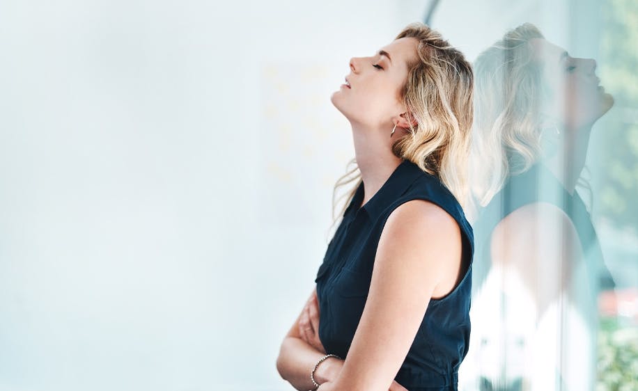 Woman stressed and leaning up against a wall