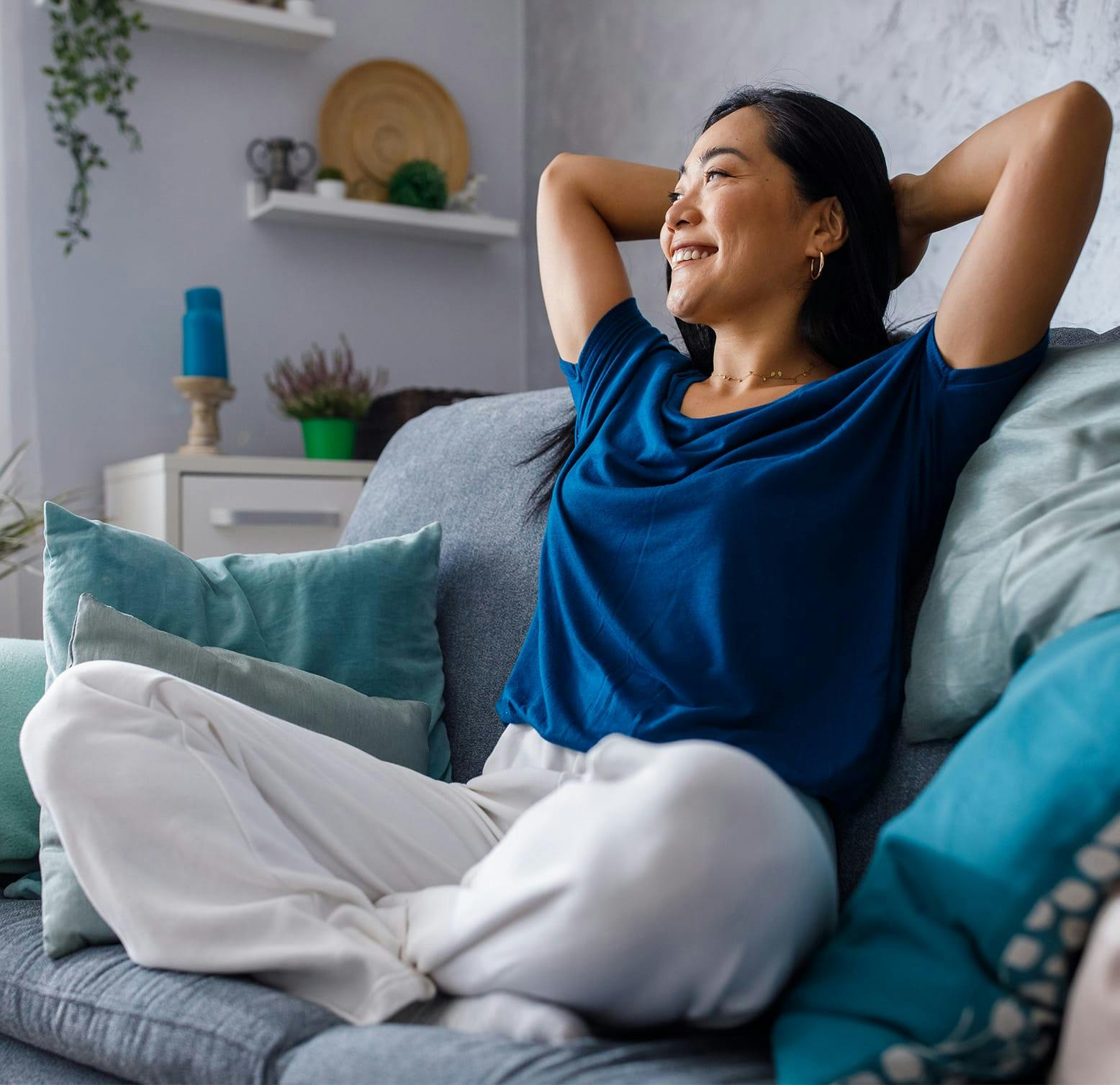 woman sitting on a couch with her arms behind her head