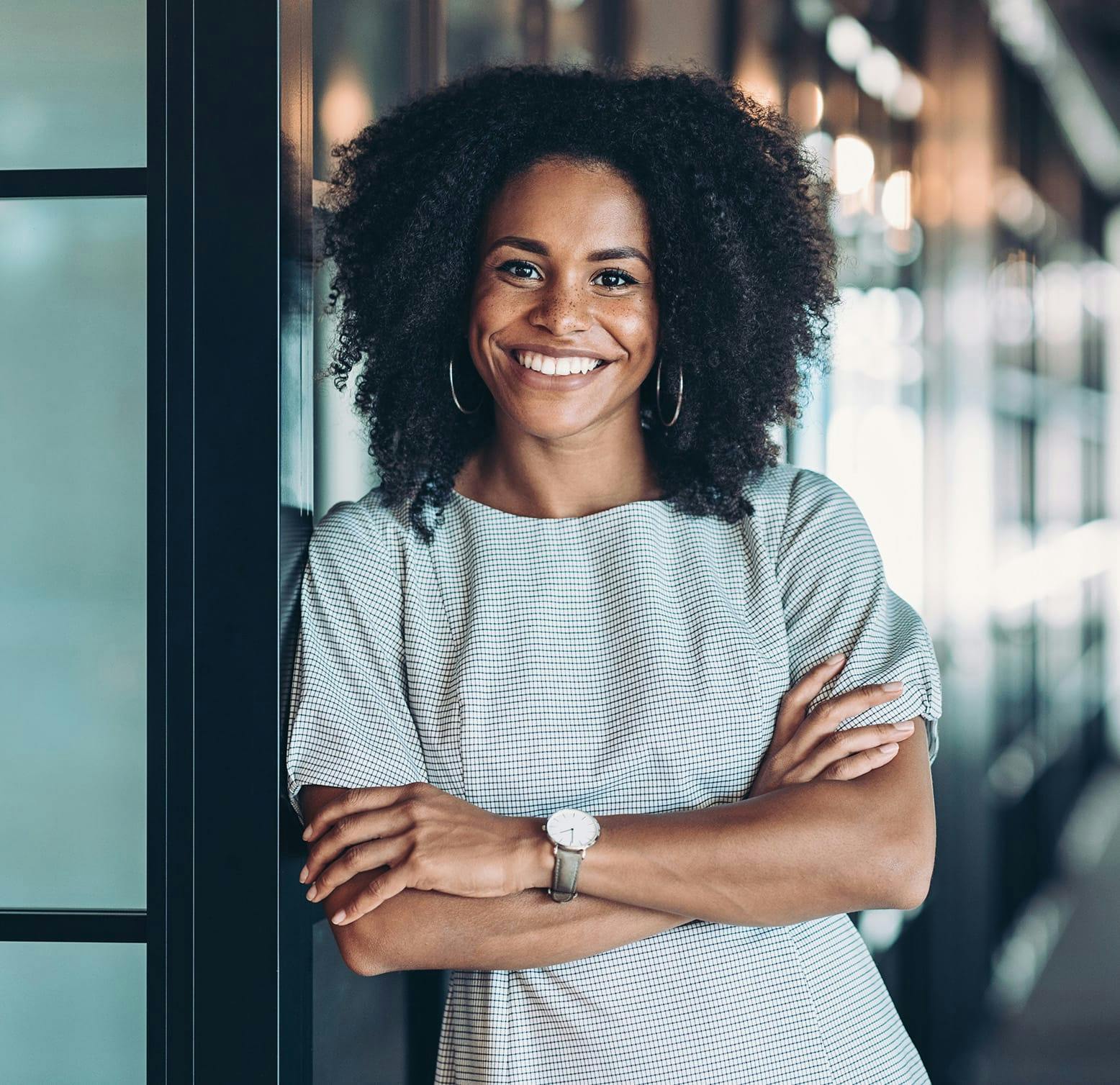 smiling woman leaning against a wall