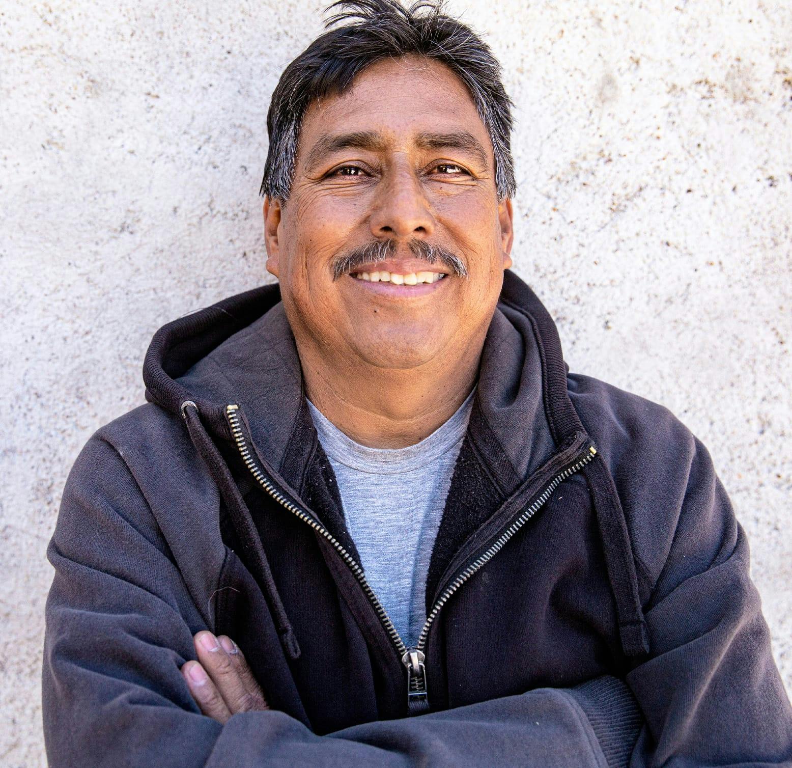 man standing against a wall with his arms crossed