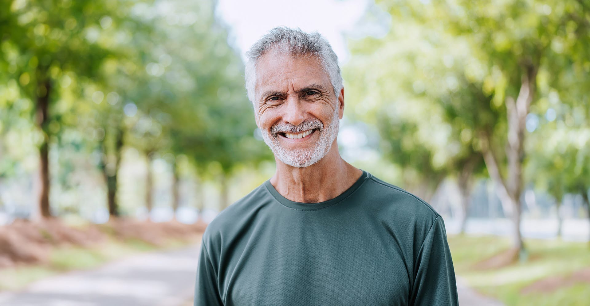smiling older man standing outside