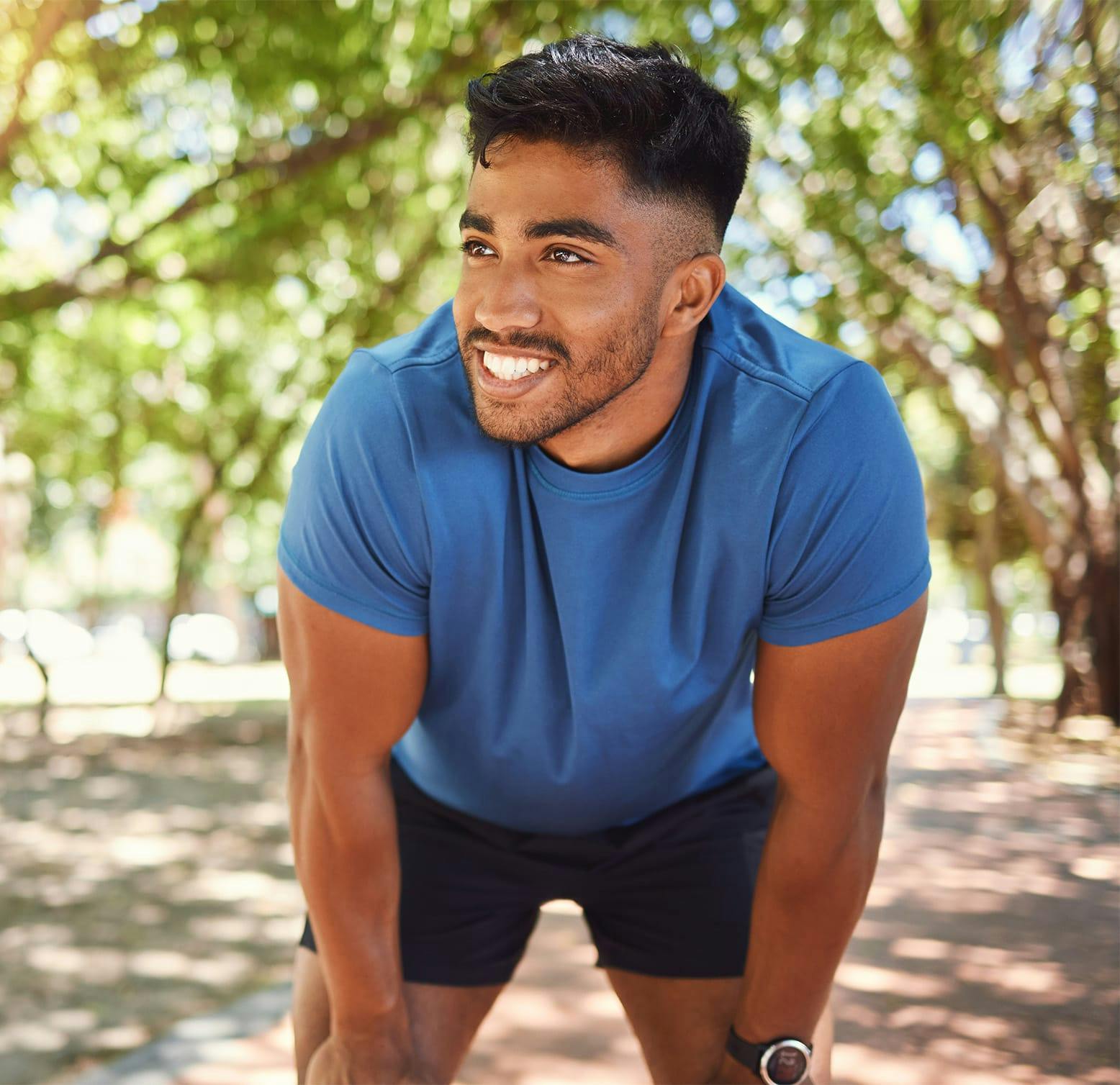 smiling man with his hands on his knees