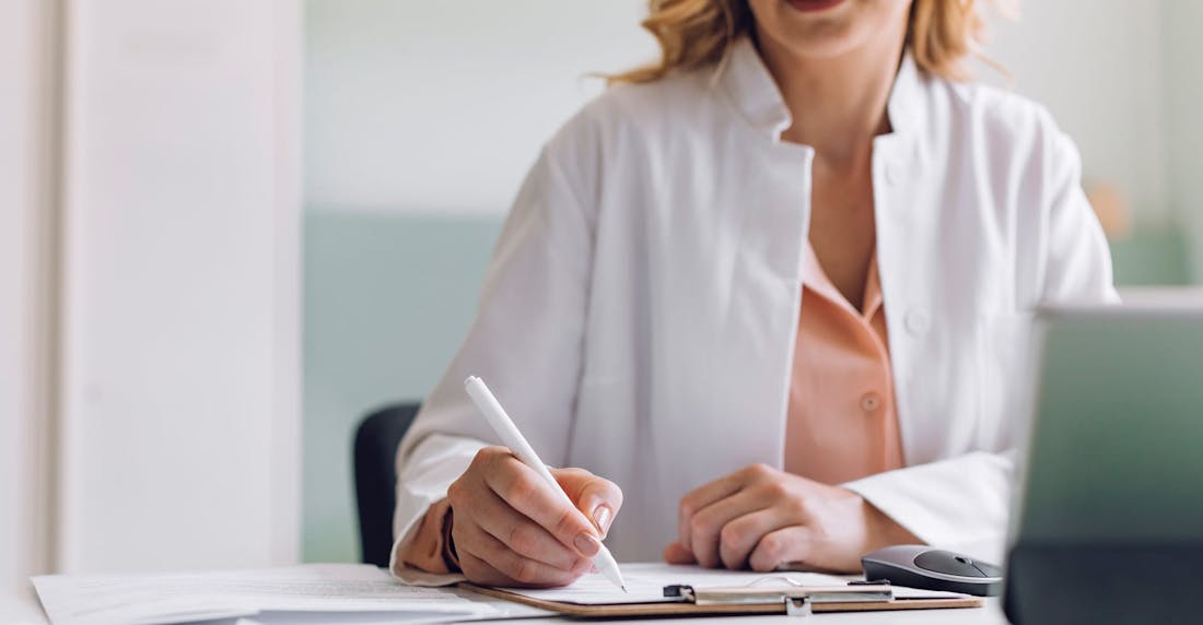 Doctor writing on her clipboard