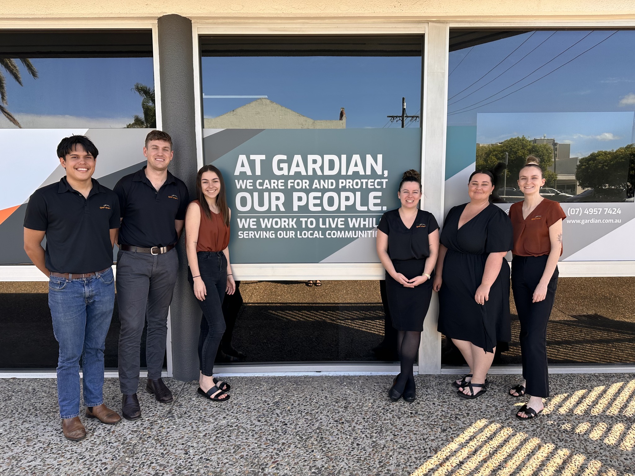 Six of the Gardian Insurance Family in front of our office in 73 Wood Street with our Why on the background.