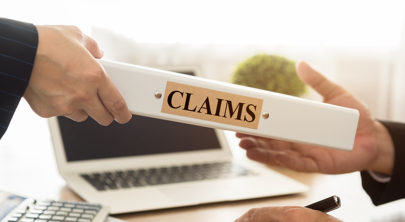 A person handing over a claims folder to another person.  Used for Gardian Insurance Blog.