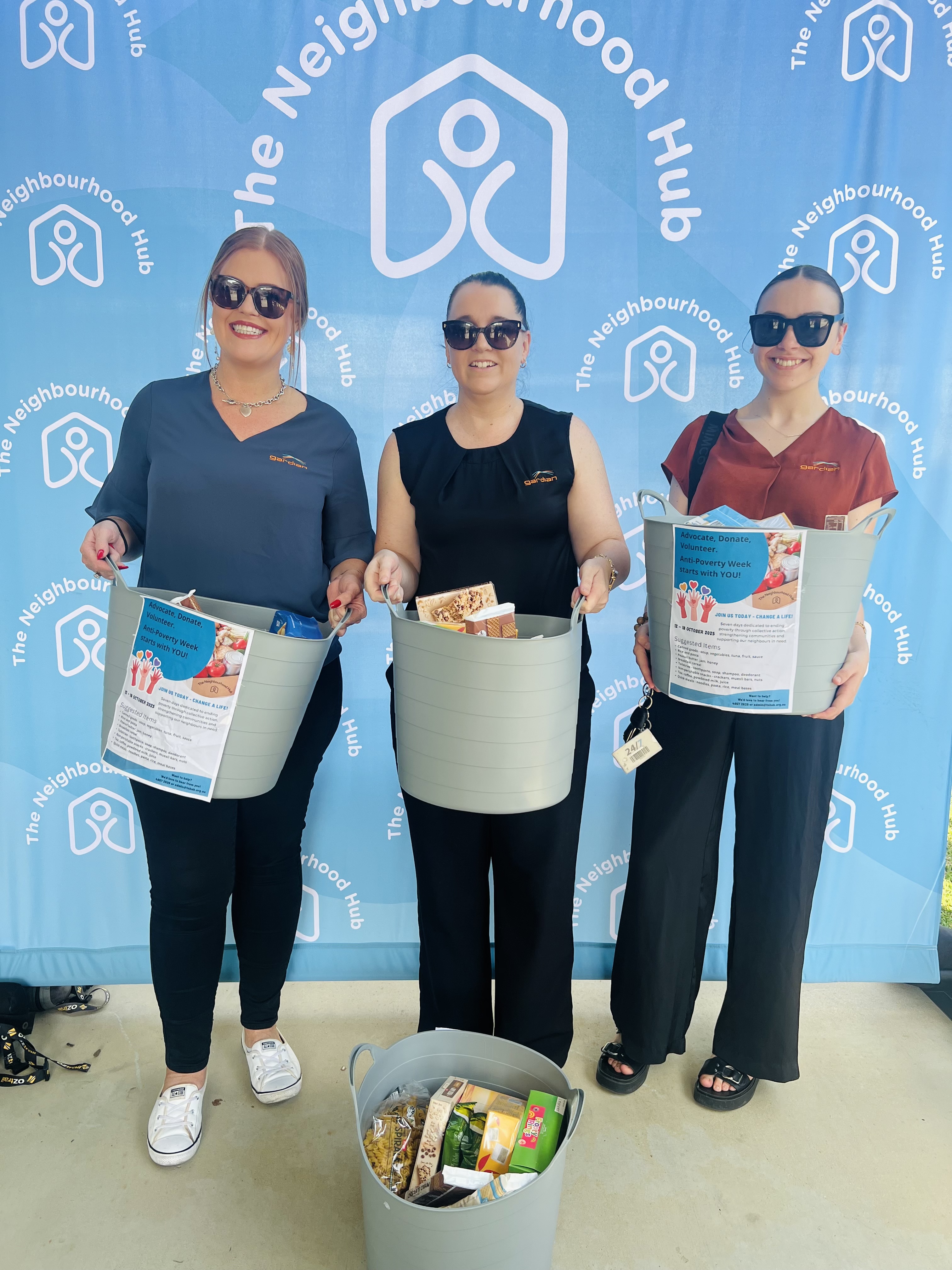 3 Ladies holding baskets full of items to be donated to The Neighbourhood Hub.