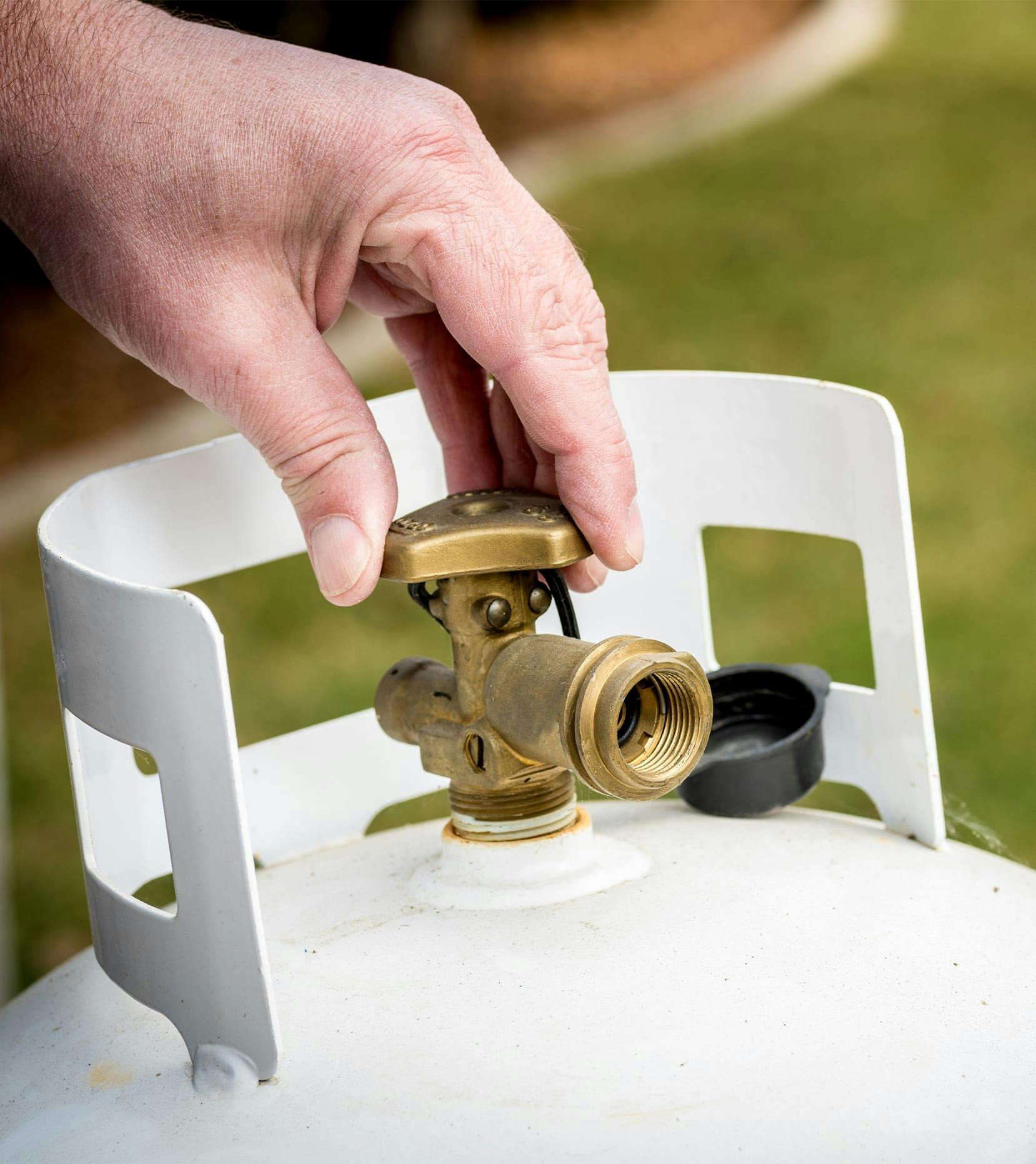 man opening 20lb propane tank valve