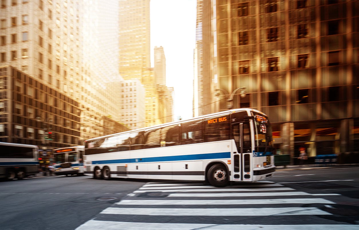 bus drivingin city during sunset