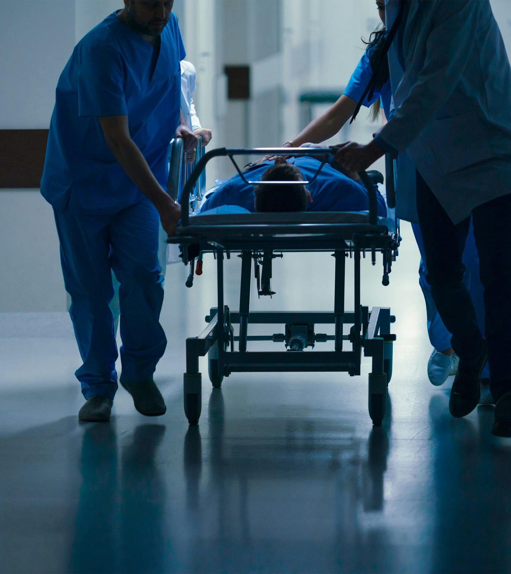 doctors wheeling patient down hallway