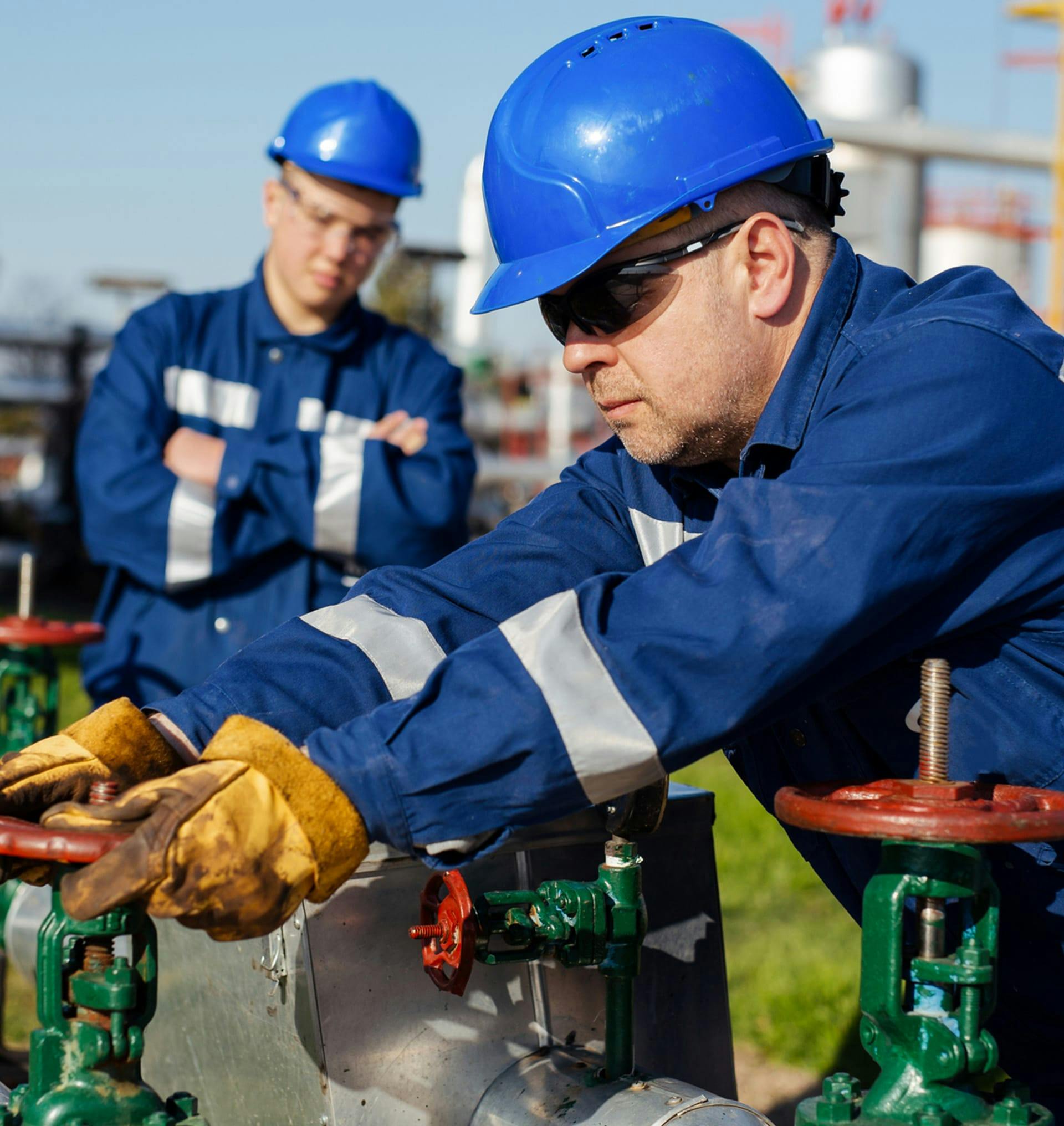 two men working on oil pipes