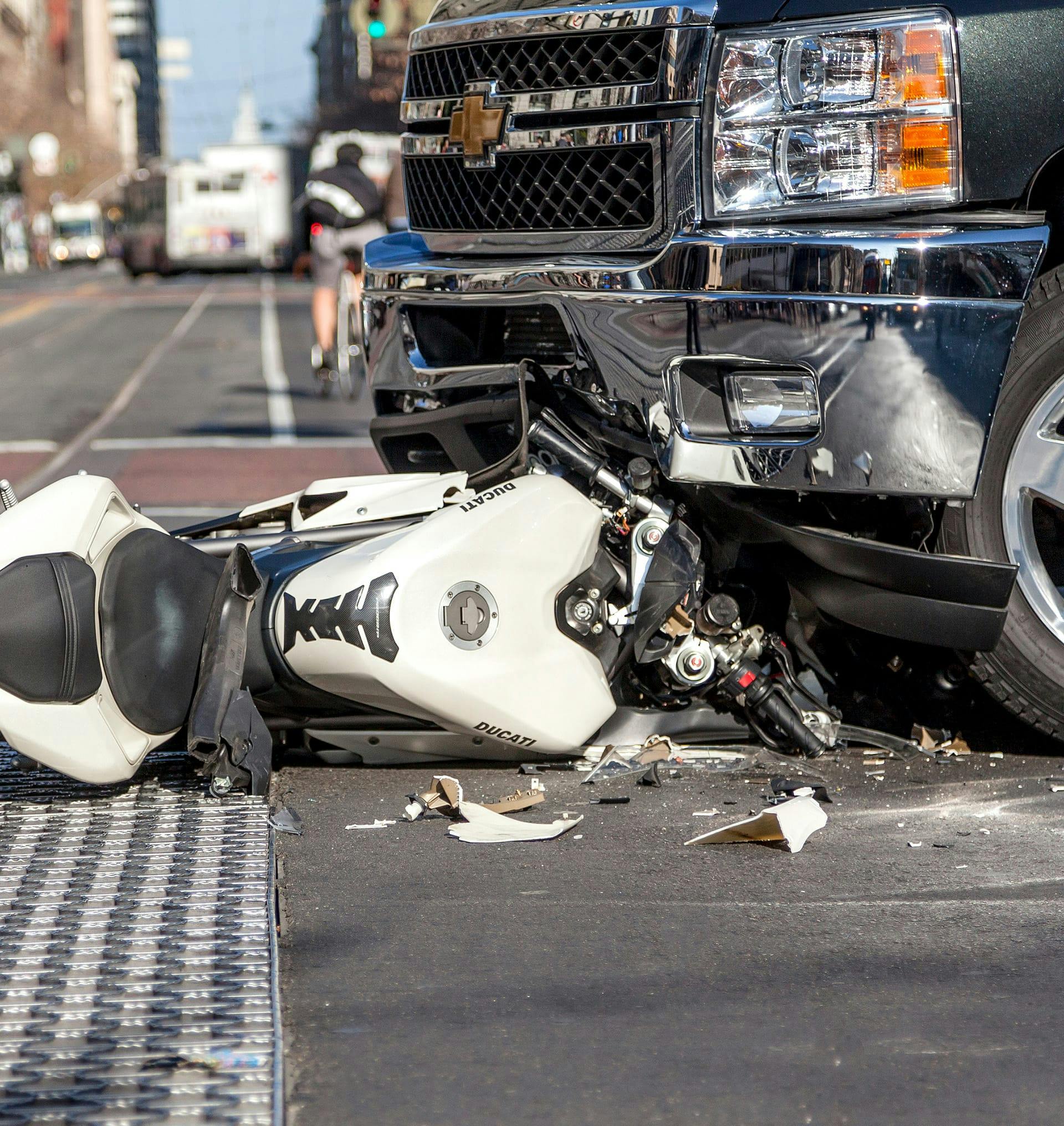 motorcycle broken under a truck