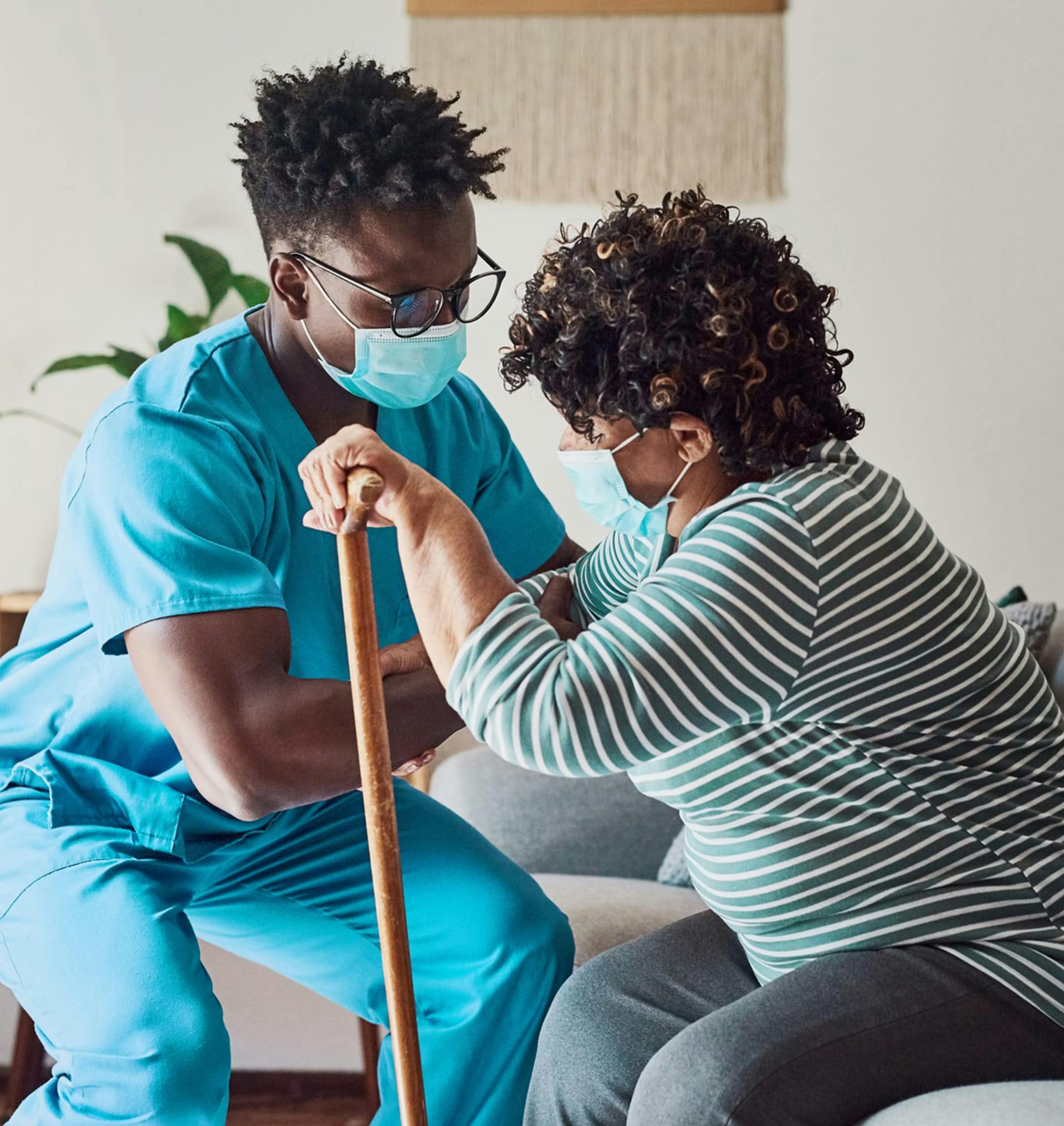 nurse helping elderly woman stand