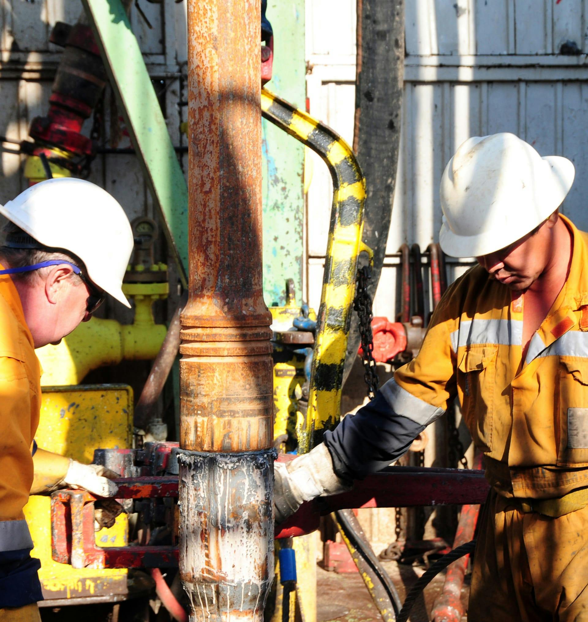 two men working on an oil drill