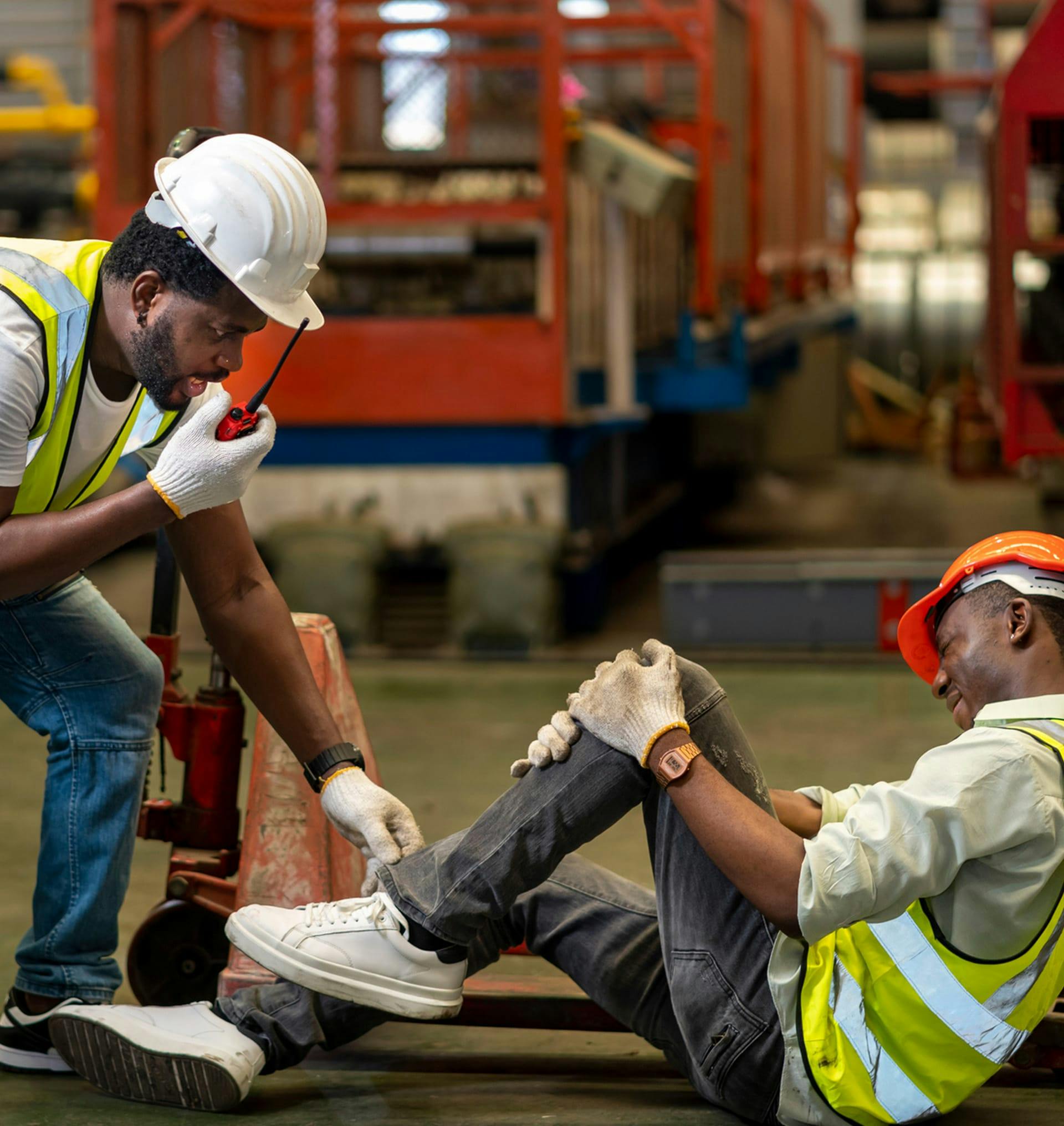 man holding injured leg while other man calls for help