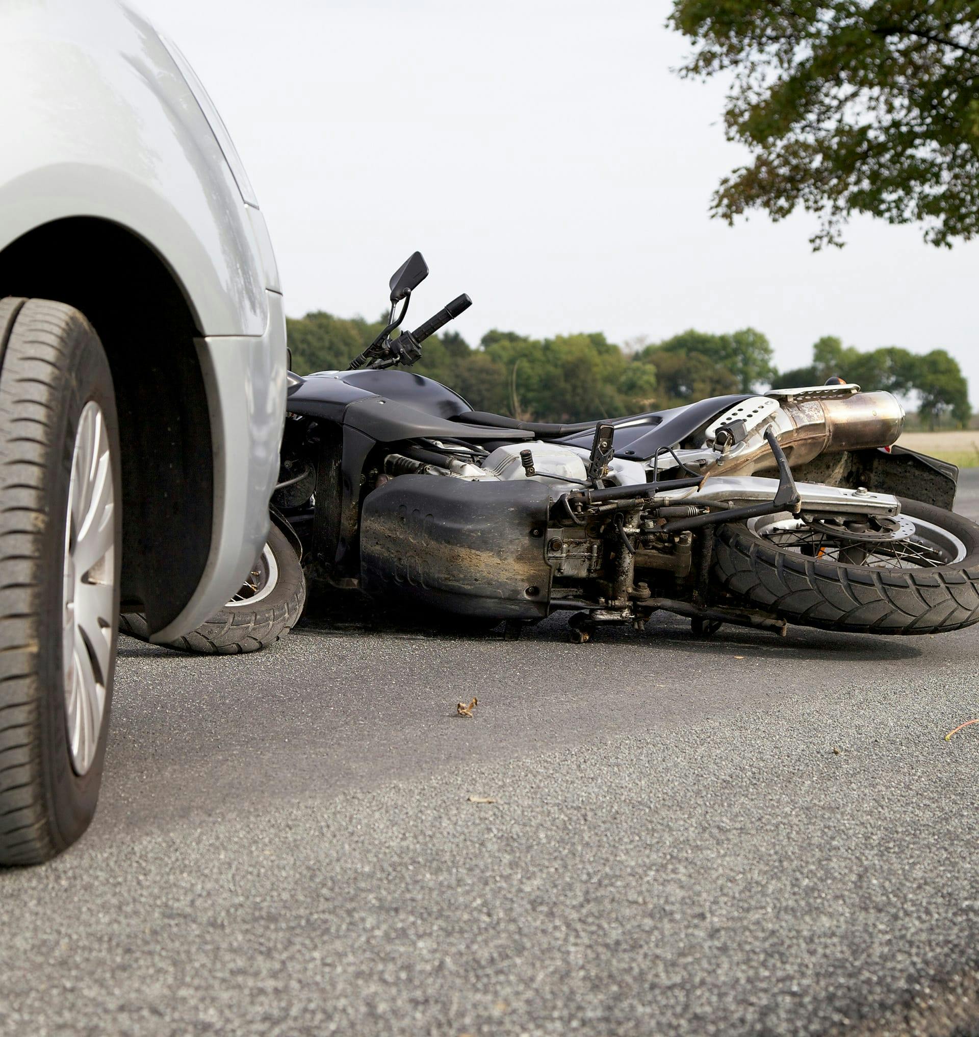 motorcycle on ground in front of car