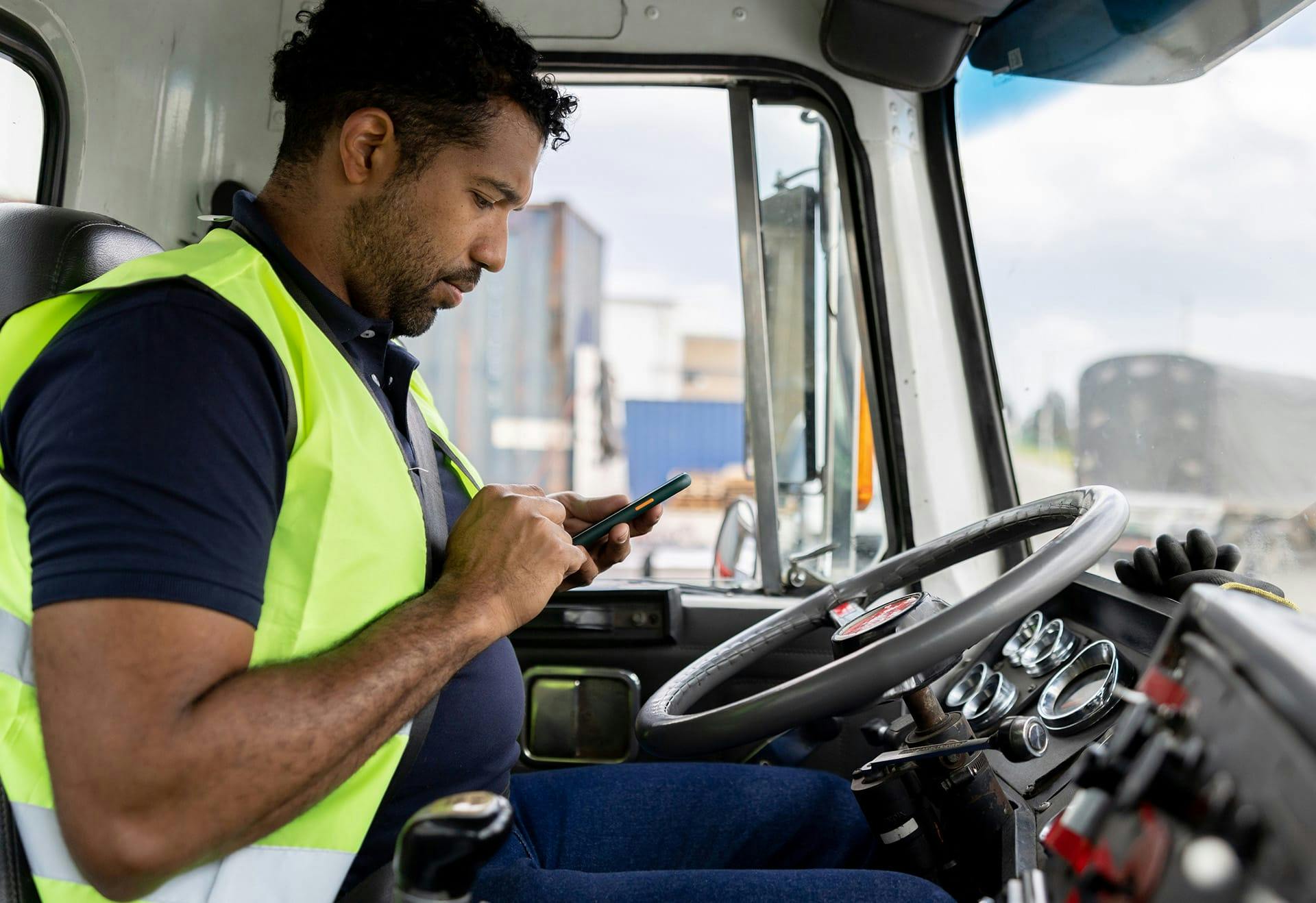 man on phone while driving a semi truck