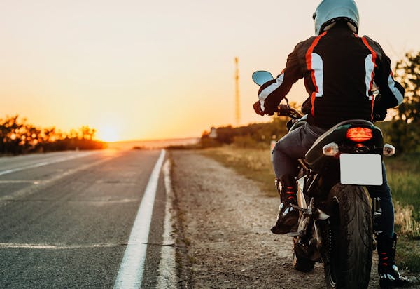 man riding motorcycle down road
