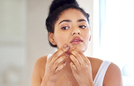 Woman examining cheek