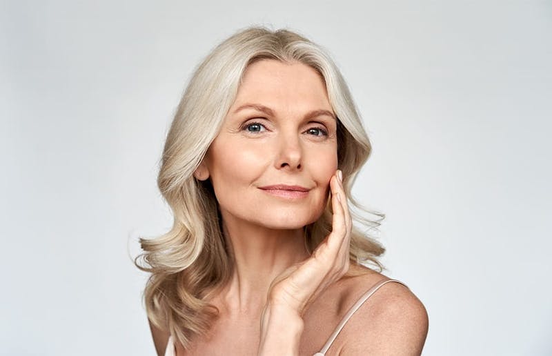 Smiling woman touching her cheek