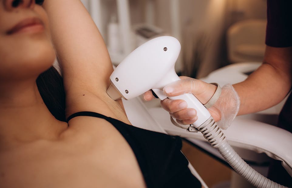 Woman receiving hair removal on armpit