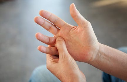person holding the base of their finger