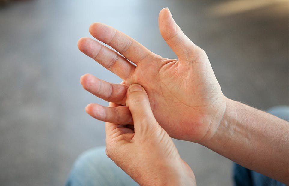 person holding the base of their finger