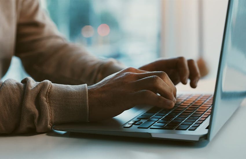 hands typing on laptop