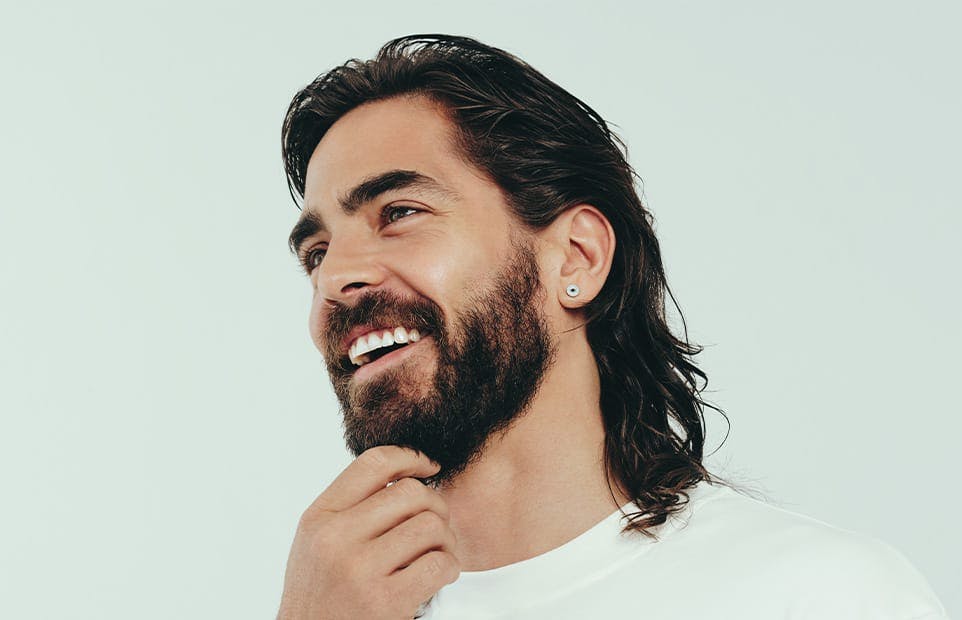 Man smiling and touching his beard