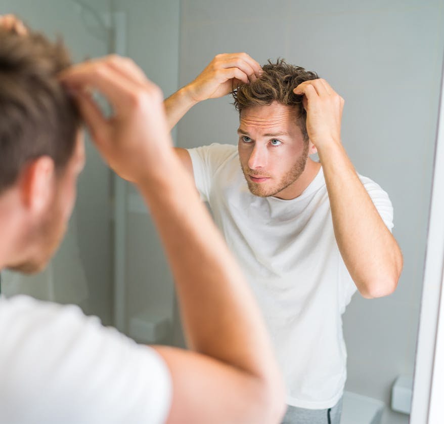 Man styling his hair in the mirror