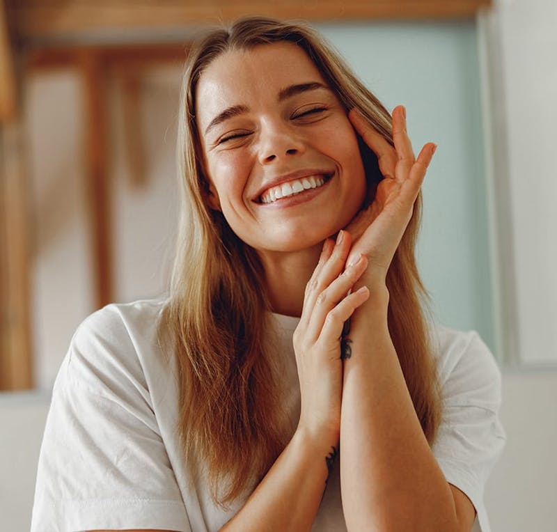 Woman smiling and touching her cheek