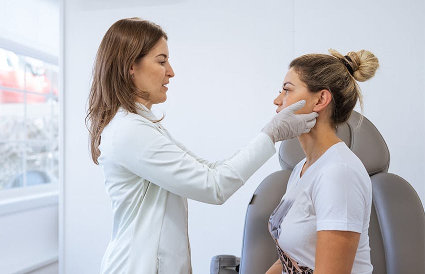 doctor checking a female patient's lower face