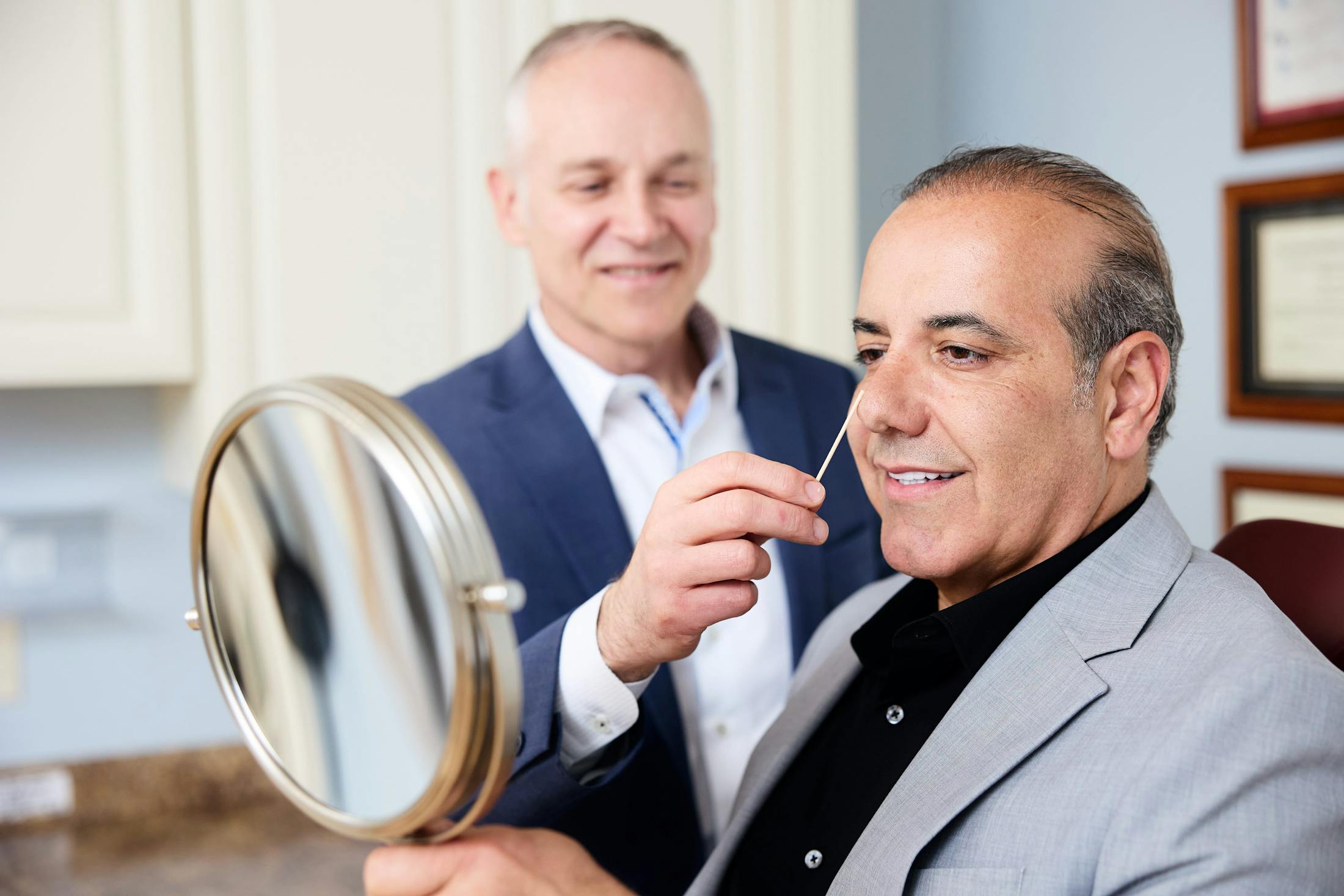 man looking in a handheld mirror