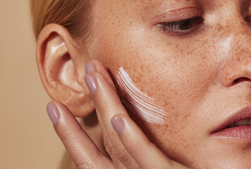 Woman applying moisturizer to her face