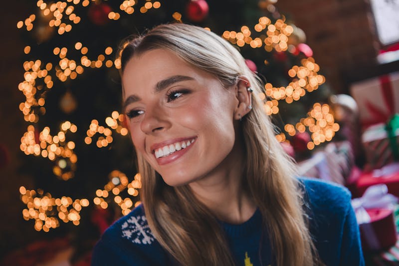 woman smiling in front of christmas tree