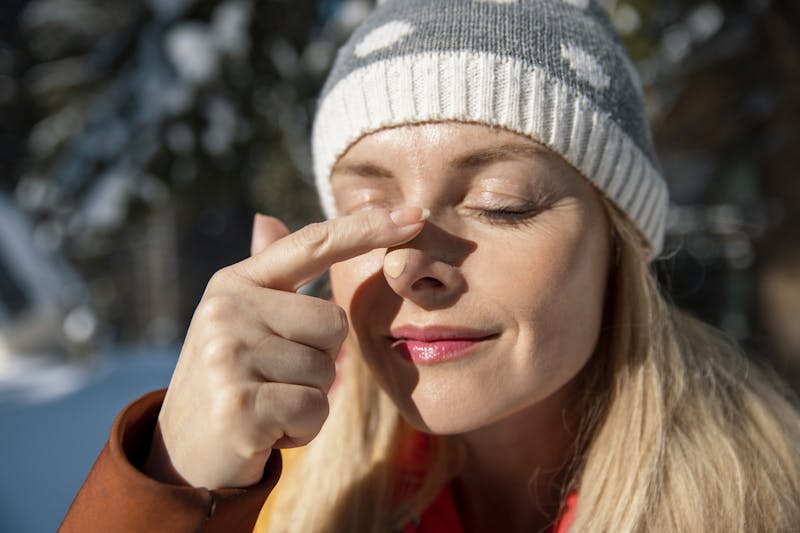 woman applying suncreen in winter