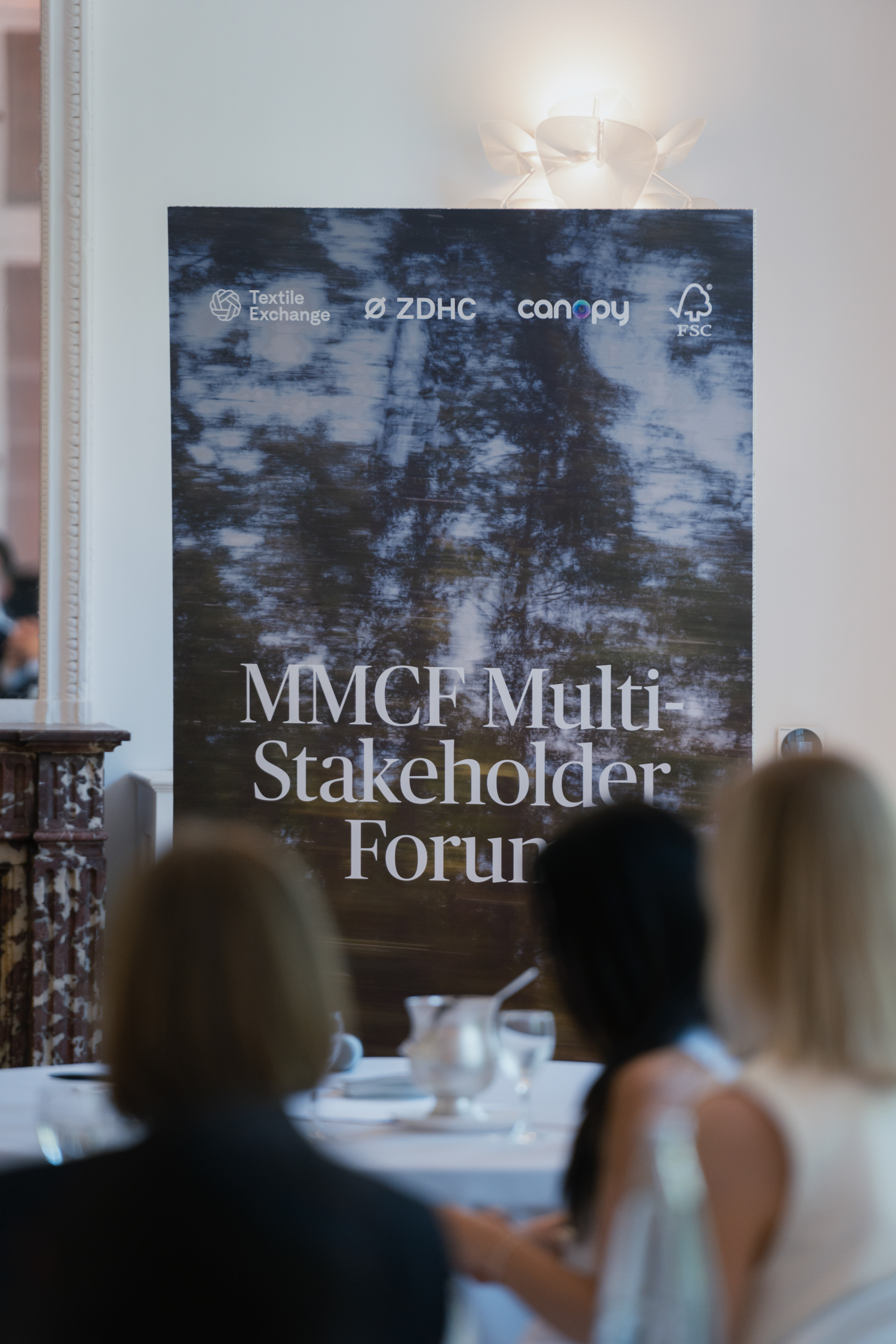 A sign at Challenge the Fabric Paris gathering reads, "MMCF Multi-Stakeholder Forum"