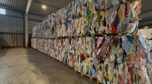 A view of a large wall of recycled textiles waiting to be processed into pulp