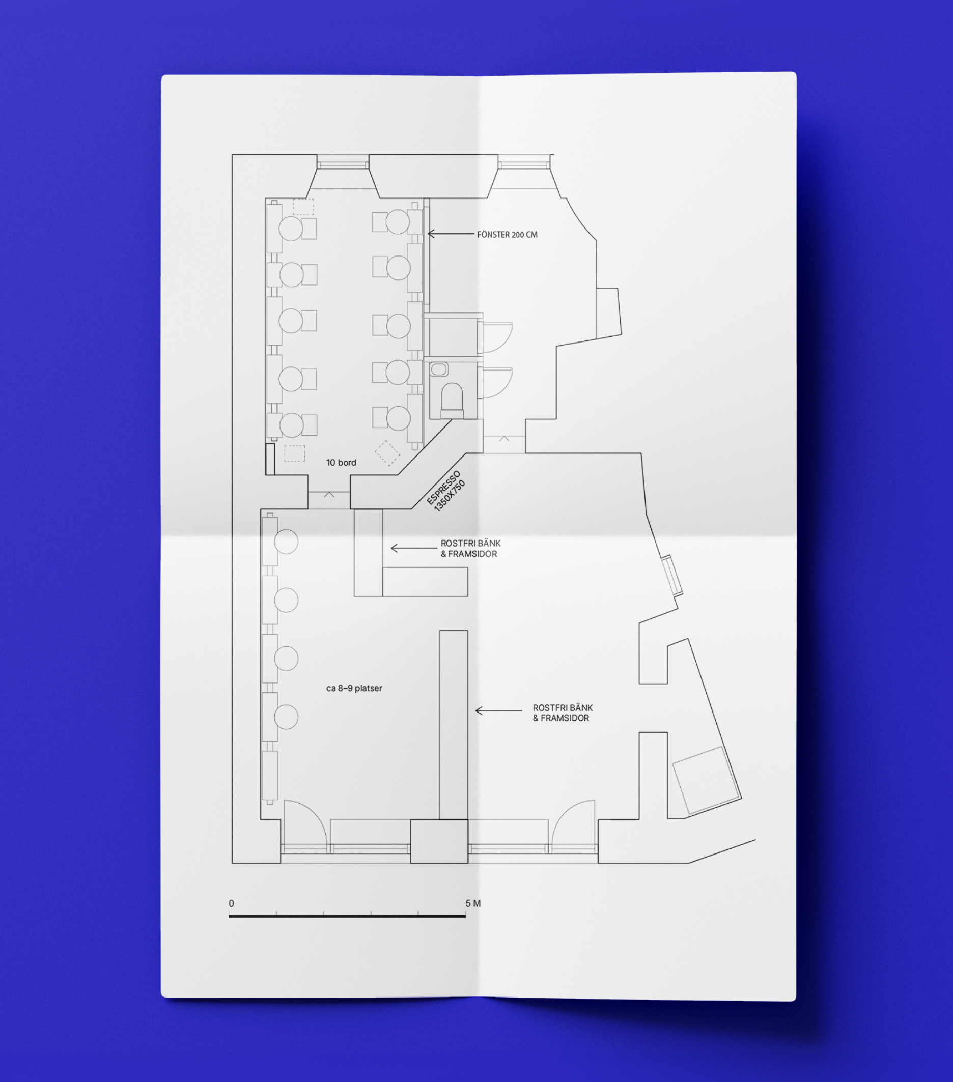 A folded paper shows a black and white floor plan of the Stora Bageriet café, placed against a blue background.
