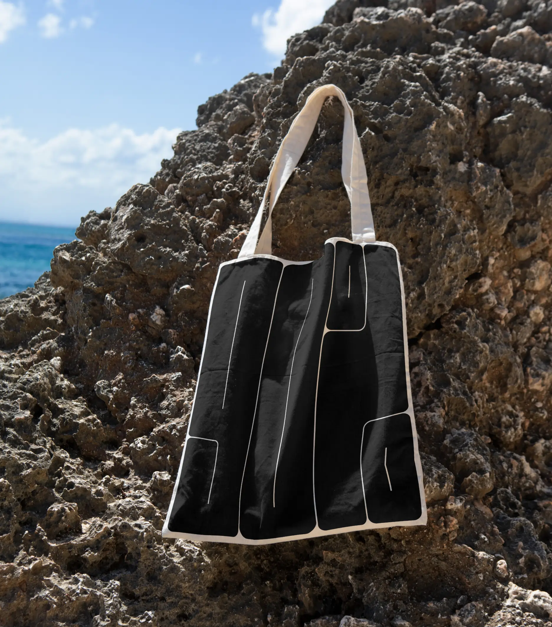 A Coors tote bag hanging on a rock at the beach A Coors tote bag hanging on a rock at the beach