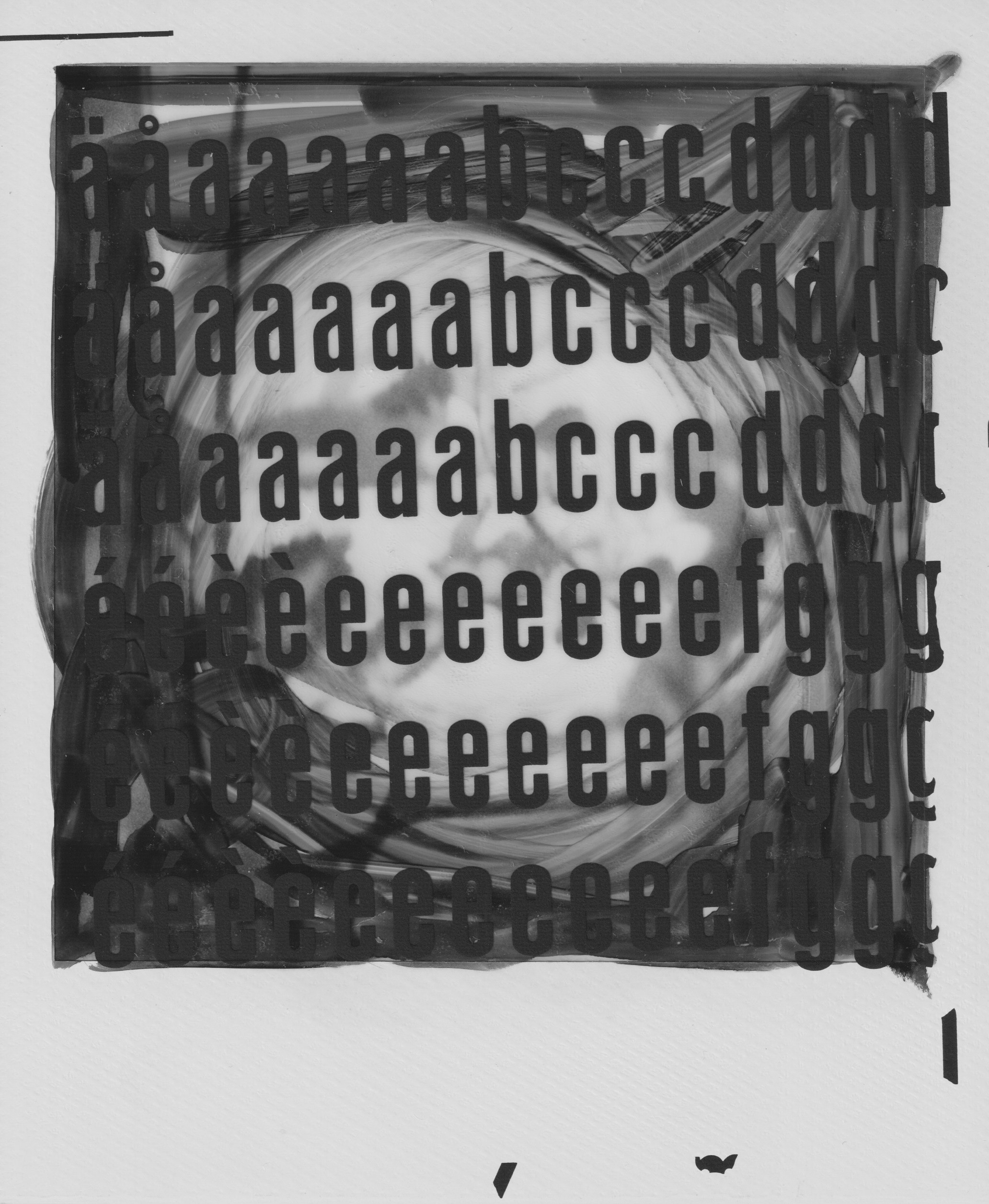 Black and white Polaroid photograph depicting a blurry somewhat abstract swirl, on top of that are letters glued onto the surface, the first letters in the alaphapeth in a slightly tilted rows all over the photograpgh.