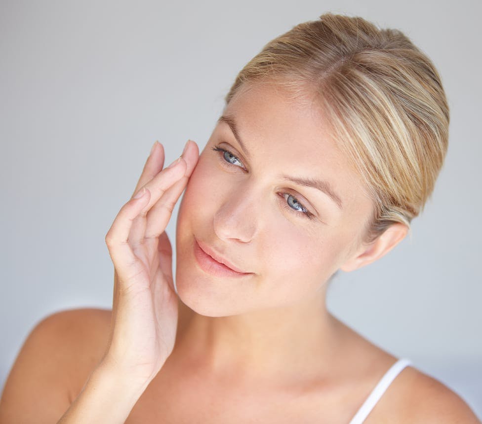 woman touching her cheek