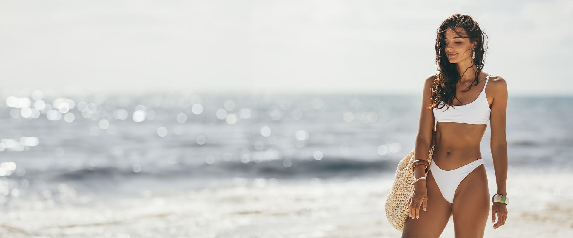 woman in a white bikini standing on a beach