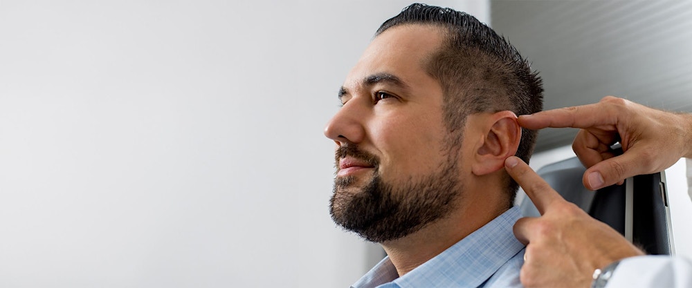 Dr. Rahban pointing at a patient's ear