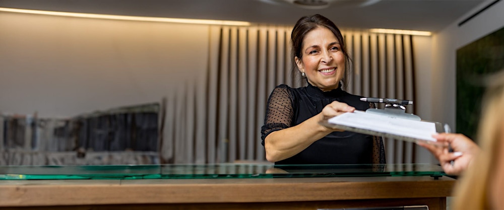 Woman handing a patient a clipboard