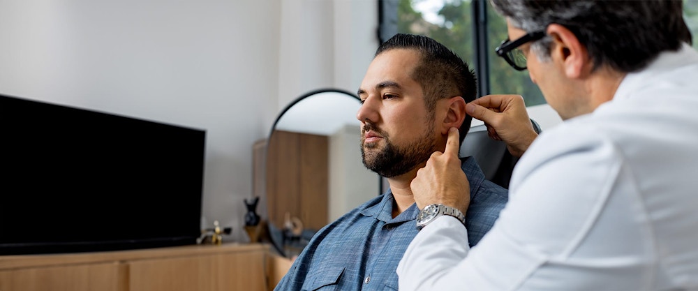 Dr. Rahban looking at a patient's ear